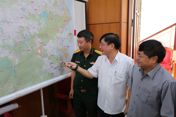 Bí thư Tỉnh ủy Bùi Văn Cường (giữa) và các đại biểu khảo sát Dự án đường cao tốc Buôn Ma Thuột - Nha Trang trên bản đồ tại hội thảo.  Ảnh: Hoàng Gia